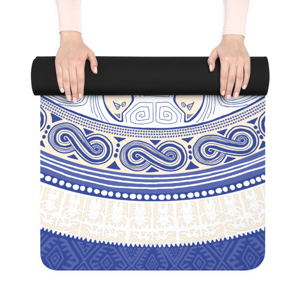 Hands unrolling the Colombian Dreams blue and white mandala yoga mat with a blue geometric border