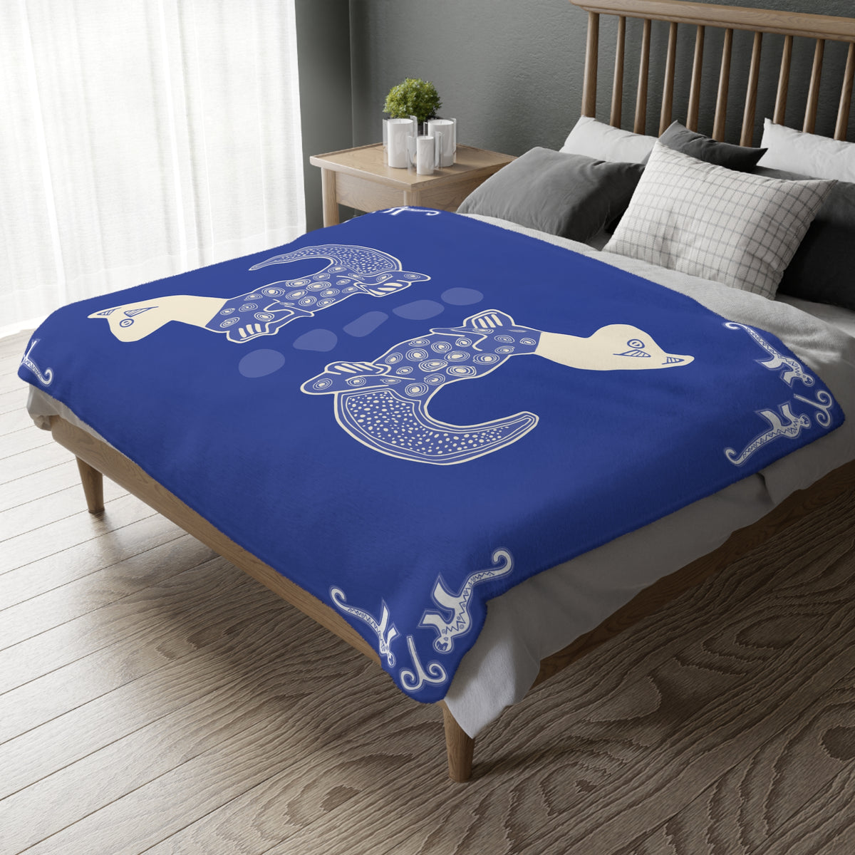 Colombian Dreams blue blanket with two cream and white patterned cats, spread over a wooden bed in a bedroom