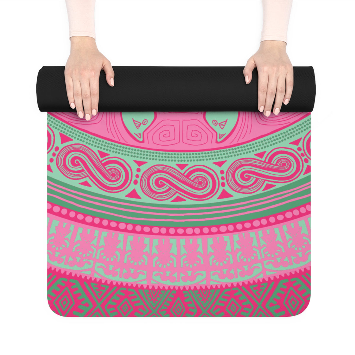 Hands unrolling the Colombian Dreams pink mandala yoga mat, showing pink and mint wave and geometric bands