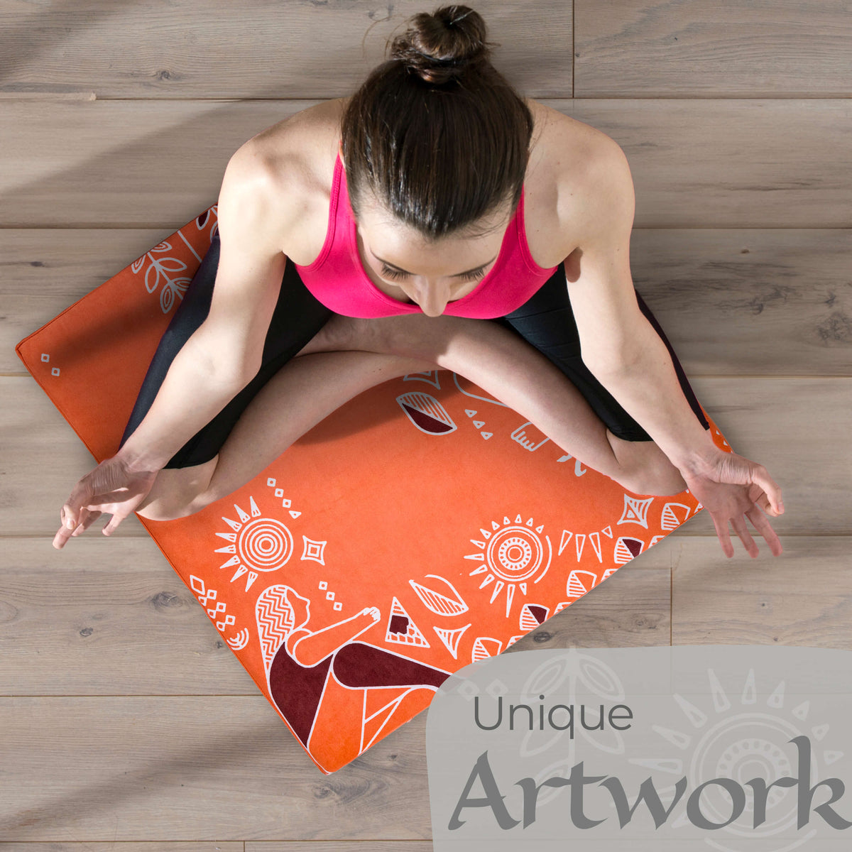 Woman meditating cross-legged on the orange Royal Court zabuton mat on a wood floor, seen from above