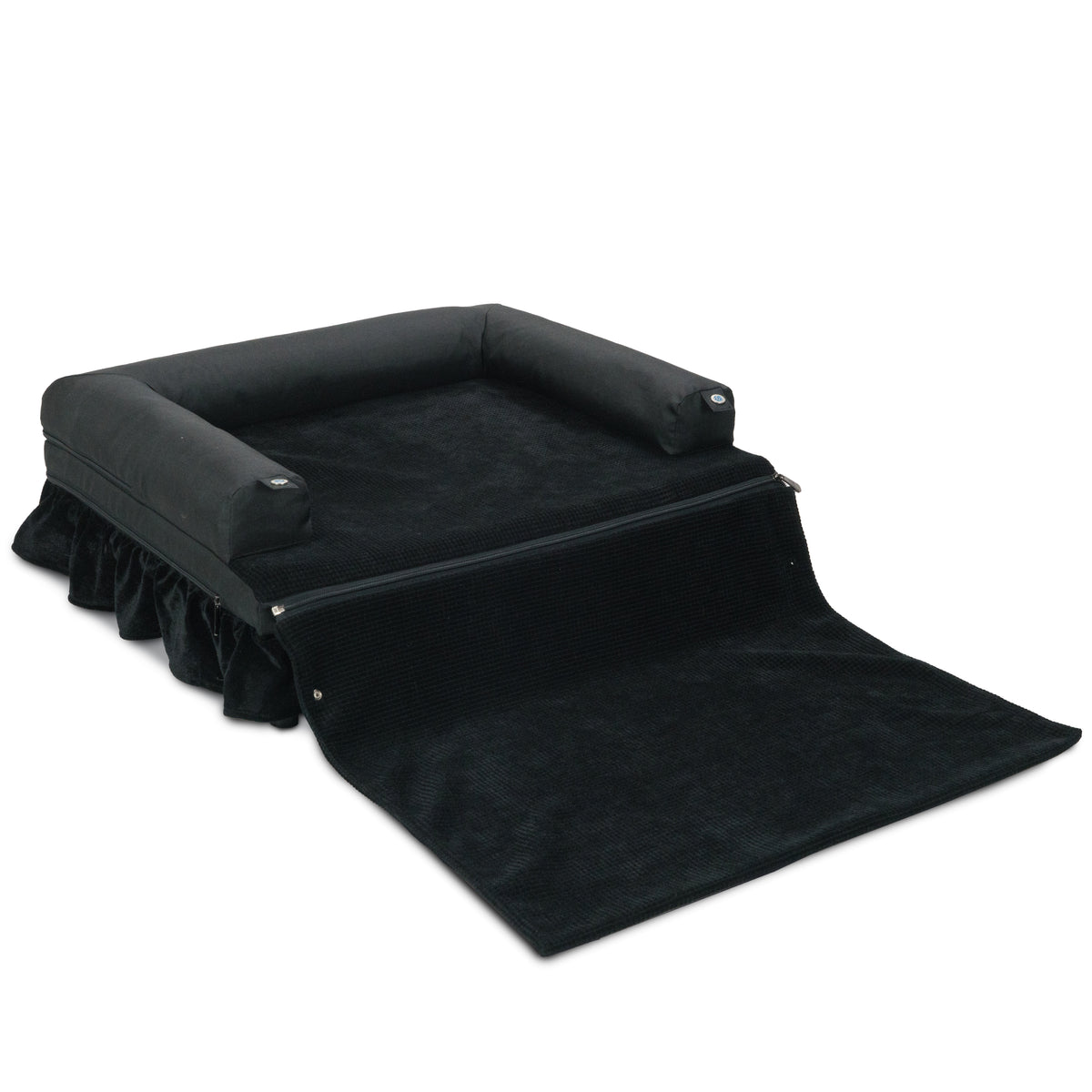 Black bolster dog bed with ruffled skirt and its zip-out blanket unfolded in front
