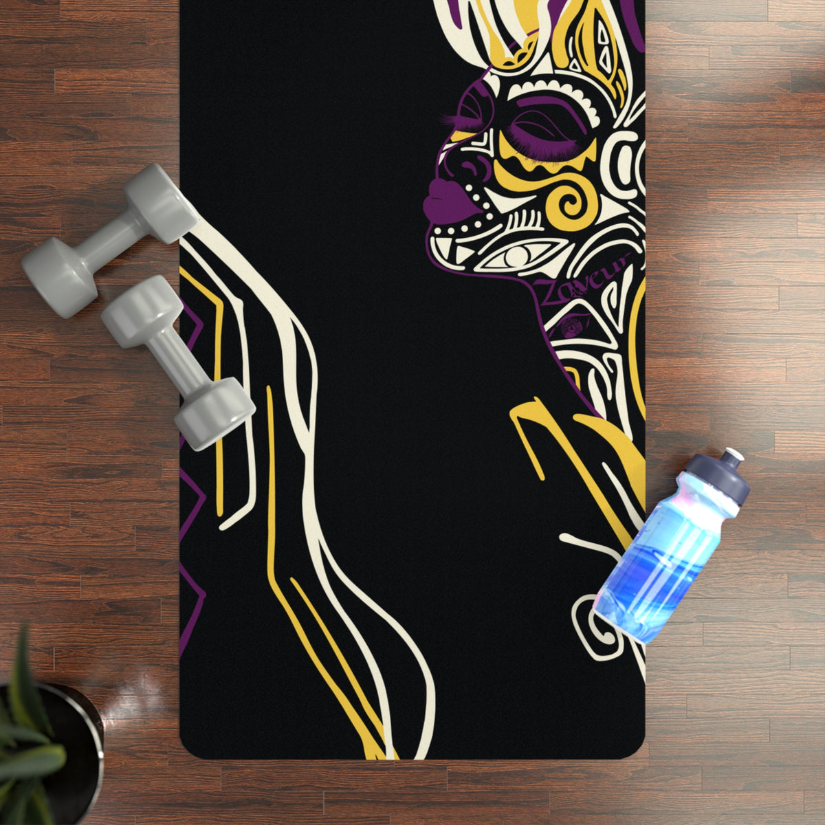 Queen of Phoenix black yoga mat with purple and yellow patterned face on a wood floor, dumbbells and bottle