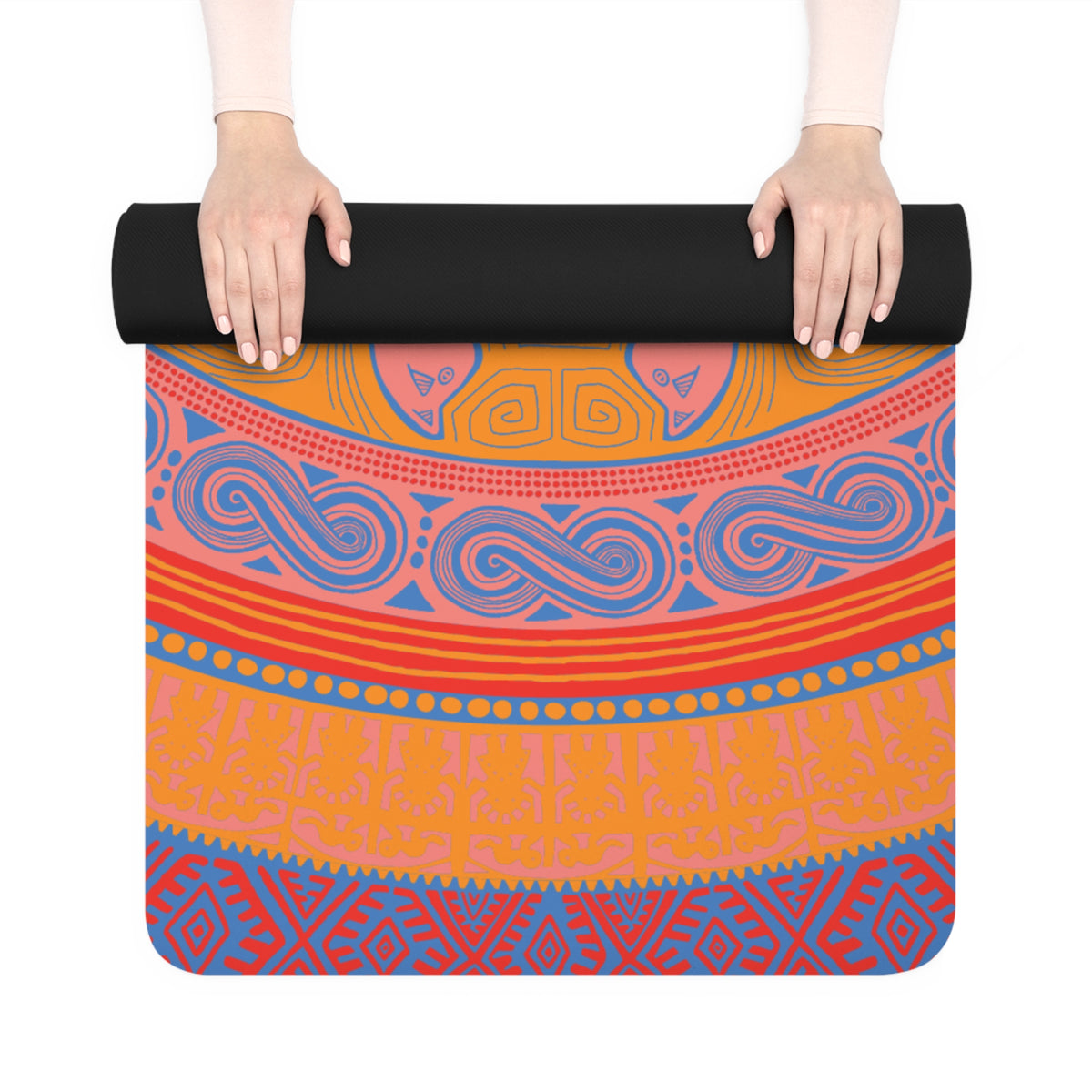 Colombian Dreams yoga mat partly unrolled by two hands, showing orange, coral, red and blue geometric bands and a black back