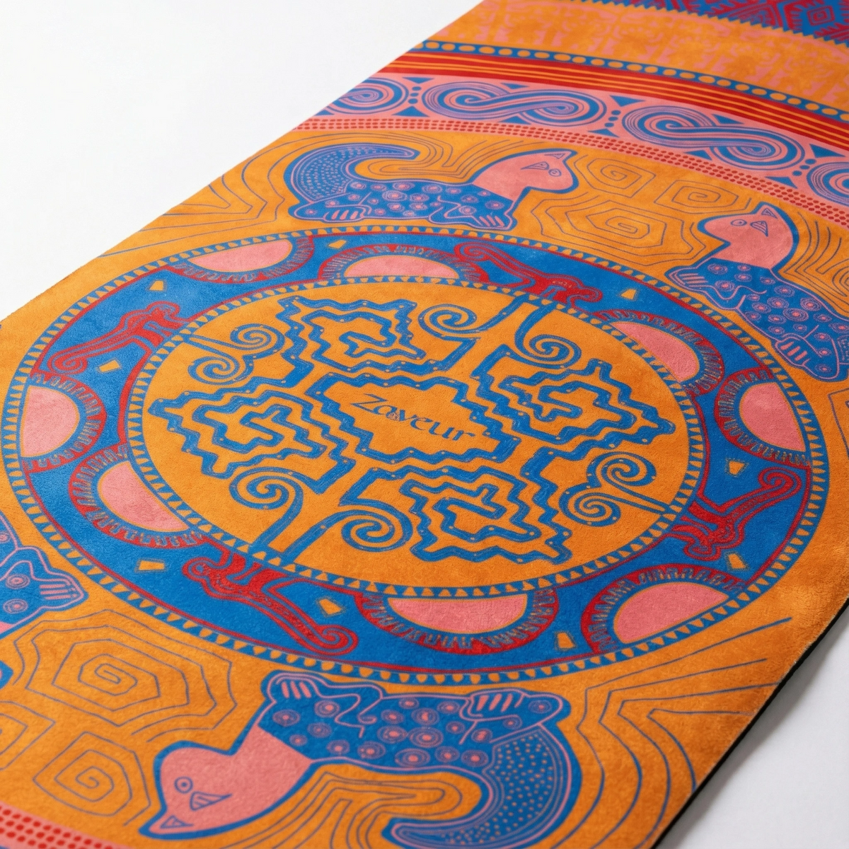 Close view of the orange Colombian Dreams yoga mat: blue mandala medallion with coral tiger figures around it
