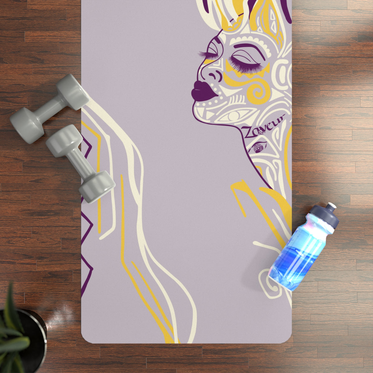 Queen of Phoenix lilac yoga mat with yellow and purple line-art face on a wood floor beside dumbbells and a bottle