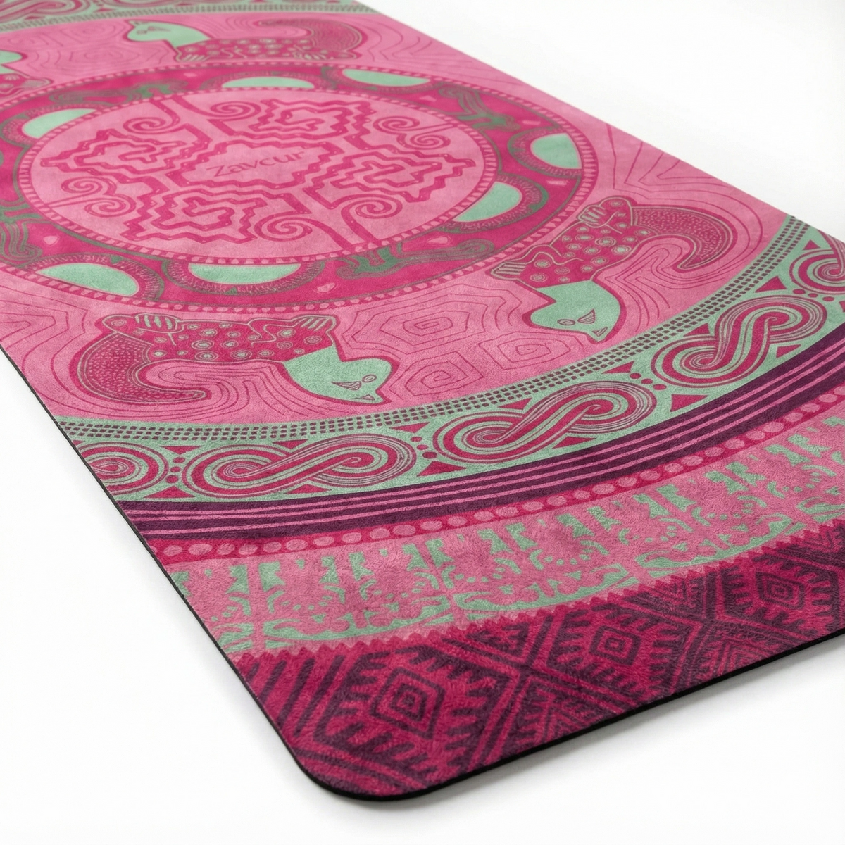 Close view of the pink Colombian Dreams yoga mat: mandala medallion, mint animal figures and a wave border