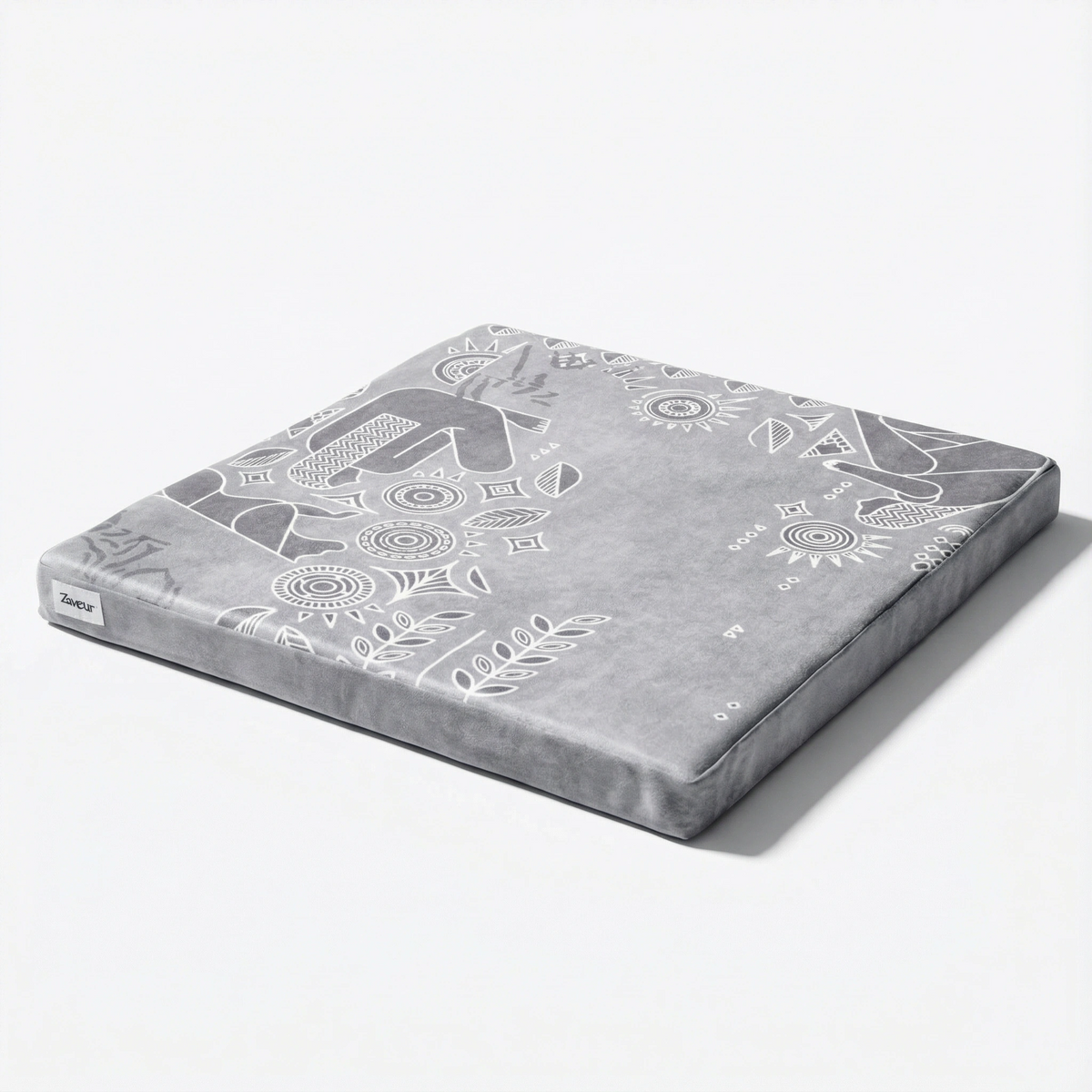 Royal Court zabuton meditation mat in grey, seen at an angle, with white line-art figures, suns and leaf shapes
